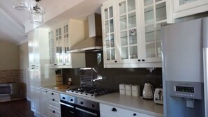 A modern kitchen with white cabinetry, a built-in stove, oven, and a water dispenser. - Blue Wren Retreat, Nannup - "Resting Place" (Nannup)