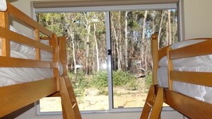 A room with two bunk beds, a window with a view of trees and a yard. - Blue Wren Retreat, Nannup - "Resting Place" (Nannup)