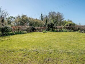 A grassy outdoor area with a wooden fence, trees, and a clear sky. - 3 bedroom accommodation in Cambridge, near Lower Cam (Cambridge, near Lower Cam)