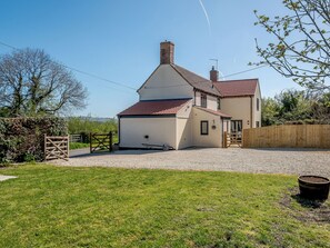 A two-story house with a red-tiled roof, a gravel driveway, and a wooden fence. - 3 bedroom accommodation in Cambridge, near Lower Cam (Cambridge, near Lower Cam)