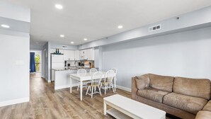 Een modern appartement met een eethoek, een bank en een keuken.