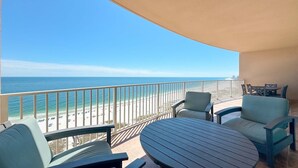 A balcony with a view of the beach and ocean. There are two chairs and a table. - New Complex!  Lazy River/Slide, Beachfront! (Orange Beach)