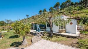 Una villa con un camino de piedra que lleva a un edificio blanco con techo de tejas.