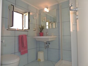 Un baño con inodoro, lavamanos y ducha.