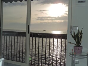 Ein Balkon mit Blick auf das Meer und einen Sonnenuntergang.