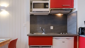 Eine kleine Küche mit Mikrowelle, Toaster und Geschirrspüler.
