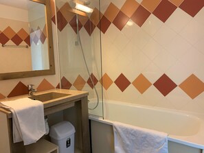 Une salle de bain avec un lavabo, un miroir et une douche.