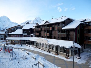 Ein mit Schnee bedecktes Gebäude mit einer Seilbahn und einem Berg im Hintergrund.