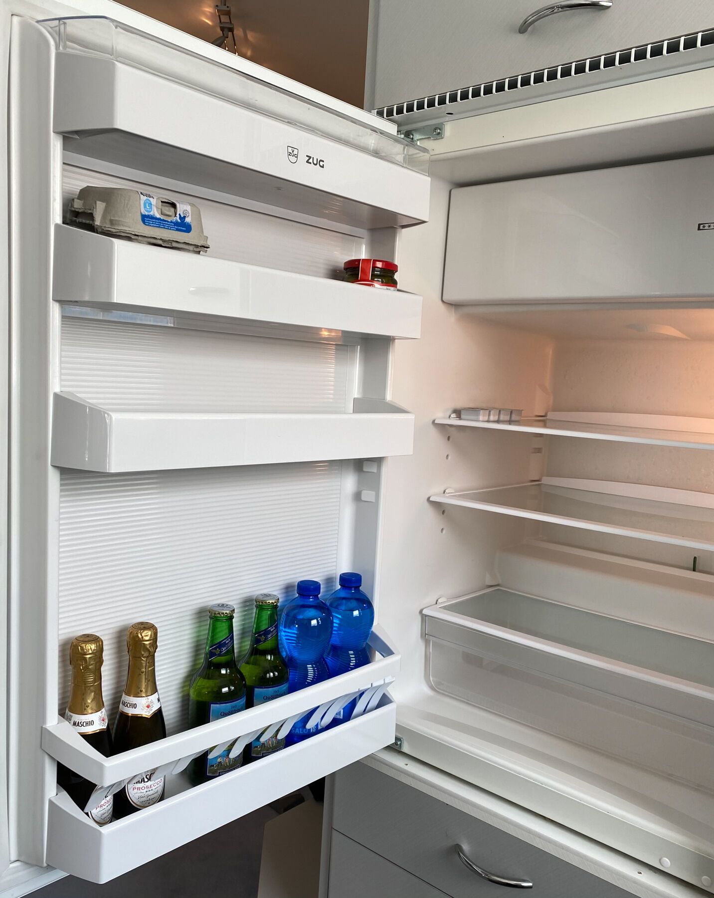 Ein Kühlschrank mit mehreren Ablagen und einem Gefrierfach.