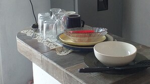 Een aanrecht met een koelkast, een spoelbak en diverse keukenbenodigdheden.