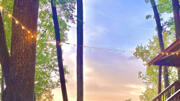 A deck with a fire pit, chairs, and a view of the mountains. - ★Cozy Log Cabin★ Secluded, modern amenities, mins to dwtwn Blueridge. Pets OK! (Blue Ridge)