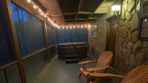 A covered outdoor area with wooden Adirondack chairs, a hot tub, and stone walls. - ★Cozy Log Cabin★ Secluded, modern amenities, mins to dwtwn Blueridge. Pets OK! (Blue Ridge)