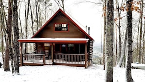 A wooden cabin with a porch, surrounded by trees and covered in snow. - ★Cozy Log Cabin★ Secluded, modern amenities, mins to dwtwn Blueridge. Pets OK! (Blue Ridge)