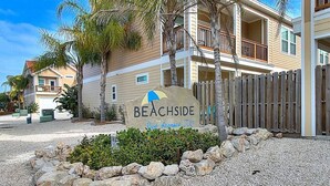 En skylt med texten ”Beachside” och en illustration av en palm och ett strandparasoll.