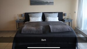 Un dormitorio con una cama grande, dos mesitas de noche y un cuadro en la pared.