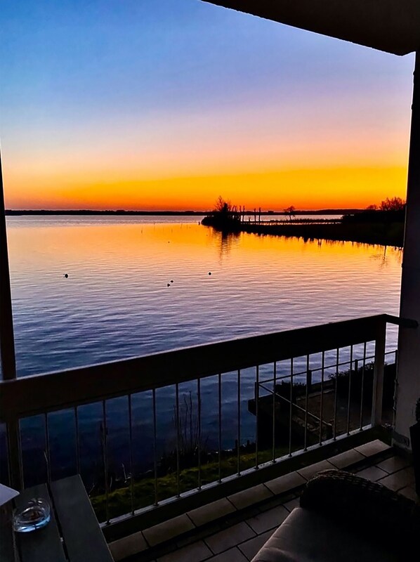 Enjoy serene waterfront views from this balcony, perfect for relaxation or dining.