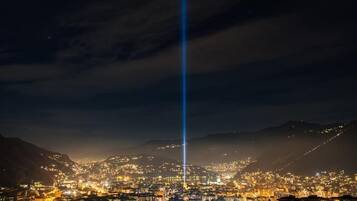 Paesaggio urbano notturno con un fascio di luce verticale ben visibile.