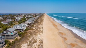 A coastal residential area with beachfront properties, including houses with balconies and a sandy beach. - Chez la Mer – Oceanfront 5BR Sanderling Home with Private Walkway & Big Views (Duck)