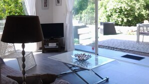 Un soggiorno moderno con TV, divano e tavolino in vetro.
