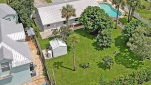 Un quartier résidentiel doté d’une piscine, de maisons et d’une route menant à un pont enjambant une étendue d’eau.
