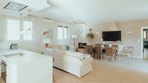 A spacious living area with a kitchen, dining table, and seating.