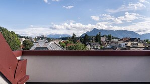 A rooftop terrace with a view of a town and mountains. - Villa Flöckner (Salzburg)
