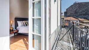 A balcony with a bed, a nightstand, and a lamp. - GuestReady - Modern luxe getaway in Vitória (Porto)