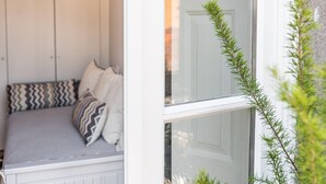 A white exterior wall with a window and a small plant. - GuestReady - Modern luxe getaway in Vitória (Porto)