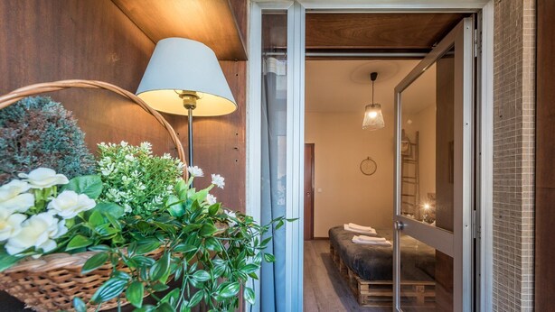 Una camera moderna con un letto, una lampada e una pianta.