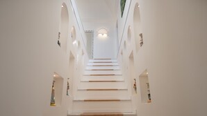 A staircase with white walls and wooden steps leading to a ceiling with a light fixture. - Luxury Villa Malika - Breathtaking view of Capri and Positano (Praiano)