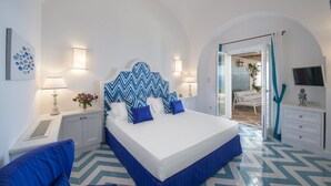 A bedroom with a large bed, white walls, and a blue and white chevron-patterned floor. - Luxury Villa Malika - Breathtaking view of Capri and Positano (Praiano)