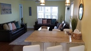Une cuisine moderne avec un îlot central, des chaises blanches et une table à manger.