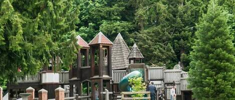 A park with wooden structures and a slide.