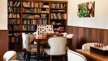 Una biblioteca con estanterías, una mesa de ajedrez y un escritorio de madera.