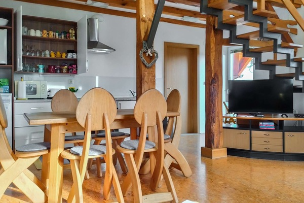 Spacious open-plan dining and living area with a television.