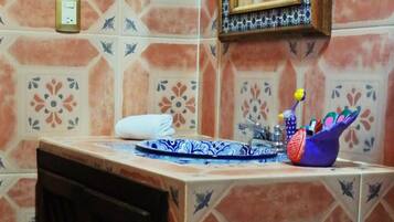 A bathroom with a sink, mirror, and decorative tiles.