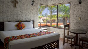 Un dormitorio con una cama grande, una mesita pequeña y una silla.