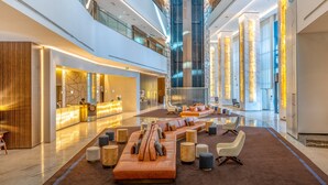 A spacious lobby with a high ceiling, a reception desk, seating area, and a large column. - Intercontinental Luanda Miramar by IHG (Luanda)