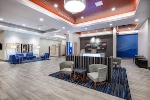 Welcome to our lobby, featuring a reception desk, comfortable seating area, and beautiful artwork on display.