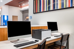 A modern office space with two desktop computers, a printer, and a keyboard on a white desk. - Holiday Inn Express & Suites Lincoln Downtown by IHG (Lincoln)