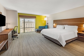 Relax in a spacious room with a large bed, desk, and comfortable seating area.