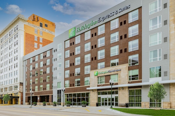 Welcome to Holiday Inn Express & Suites, featuring a modern design with a combination of brick and glass facades.