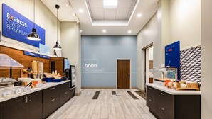 A modern hotel lobby with a breakfast bar, a 'Good Morning' sign, and a 'This is how we roll' sign. - Holiday Inn Express & Suites Lincoln Downtown by IHG (Lincoln)
