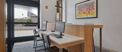 Un espacio de oficina moderno con un escritorio, dos monitores y una silla.