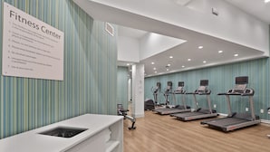 A fitness center with treadmills, a weight bench, and a sign listing rules. - Hotel 1200 (Brooklyn)