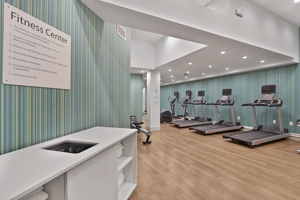 A fitness center with treadmills, a weight bench, and a sign listing rules. - Hotel 1200 (Brooklyn)