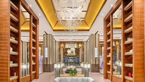 A spacious lobby with a central seating area, wooden bookshelves, and a modern chandelier. - HUALUXE Suzhou Bay Hot Spring Resort by IHG (Suzhou)