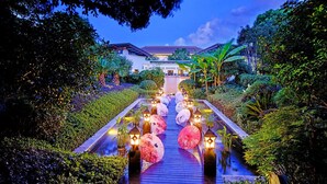 A pathway leading to a building surrounded by lush greenery and illuminated by lanterns. - HUALUXE Suzhou Bay Hot Spring Resort by IHG (Suzhou)