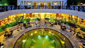 A multi-level outdoor pool area with seating and a central water feature. - HUALUXE Suzhou Bay Hot Spring Resort by IHG (Suzhou)