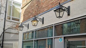 En byggnad med en skylt som visar texten ”POPESHED COURT” och en YorkHub-skylt på dörren.